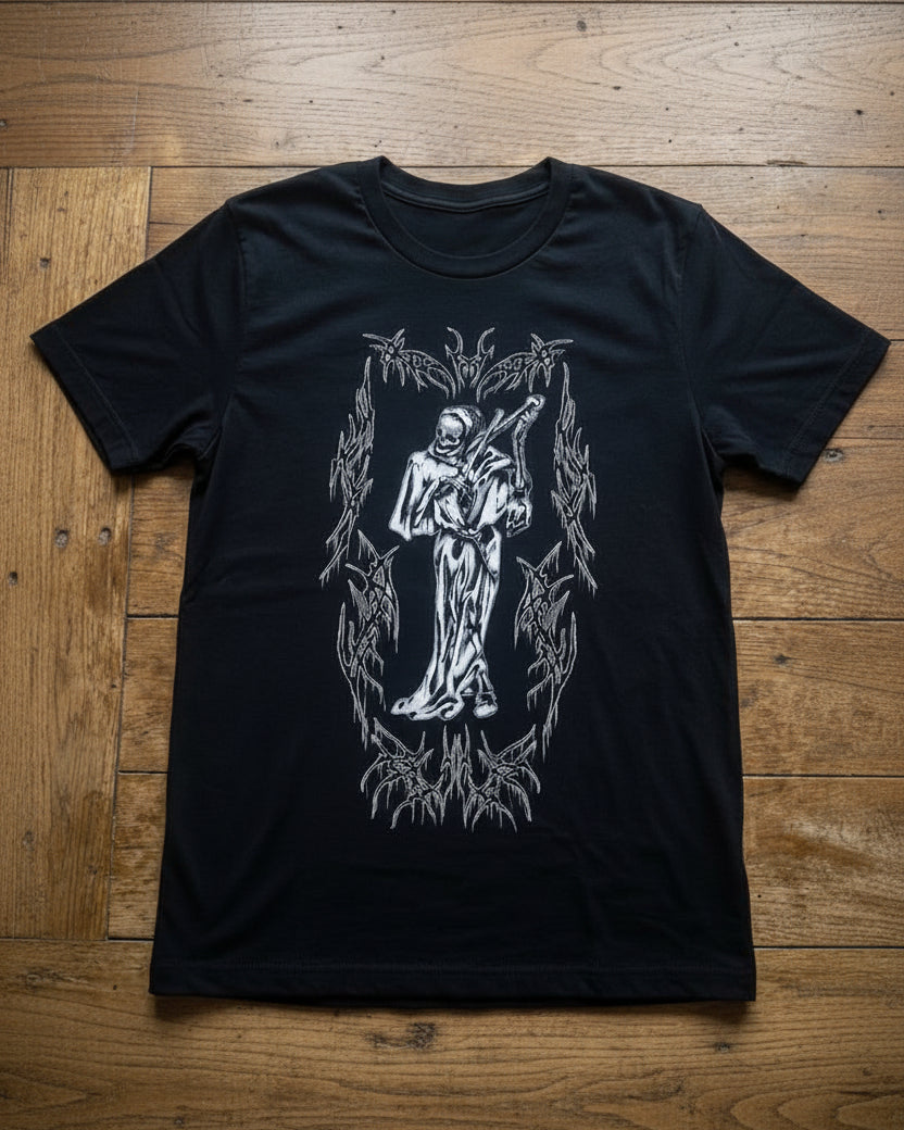 Vista del diseño principal, diseño de frente de la camiseta negra Motley Tribal Reaper. Se aprecia el tamaño del estampado de la parca en el pecho y el cuello redondo estructurado. Streetwear de autor Tattoo Roots.
