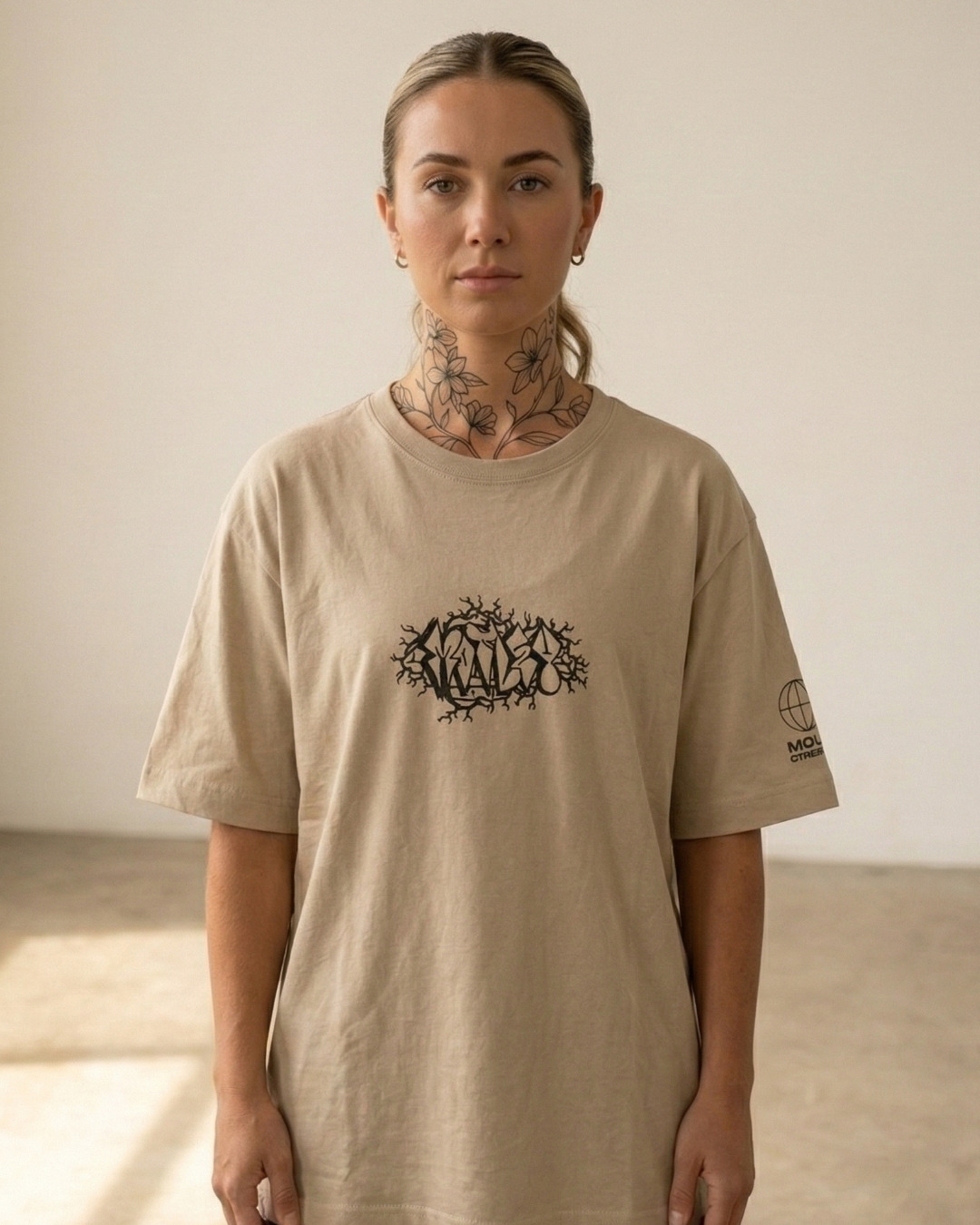 Camiseta cuello redondo de autor Colección Cruda Vibra, fit holgado, diseño minimalista en el pecho por Motley en modelo Mujer