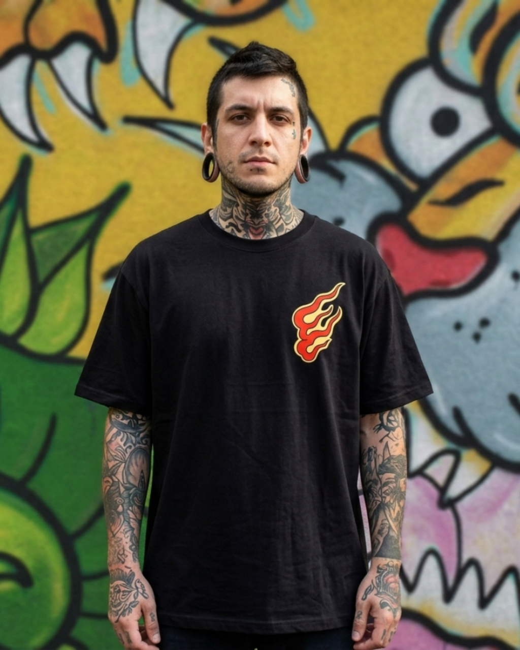Modelo masculino con tatuajes usando camiseta negra Oni no Hono. Detalle del diseño de llama técnica tradicional en el pecho.