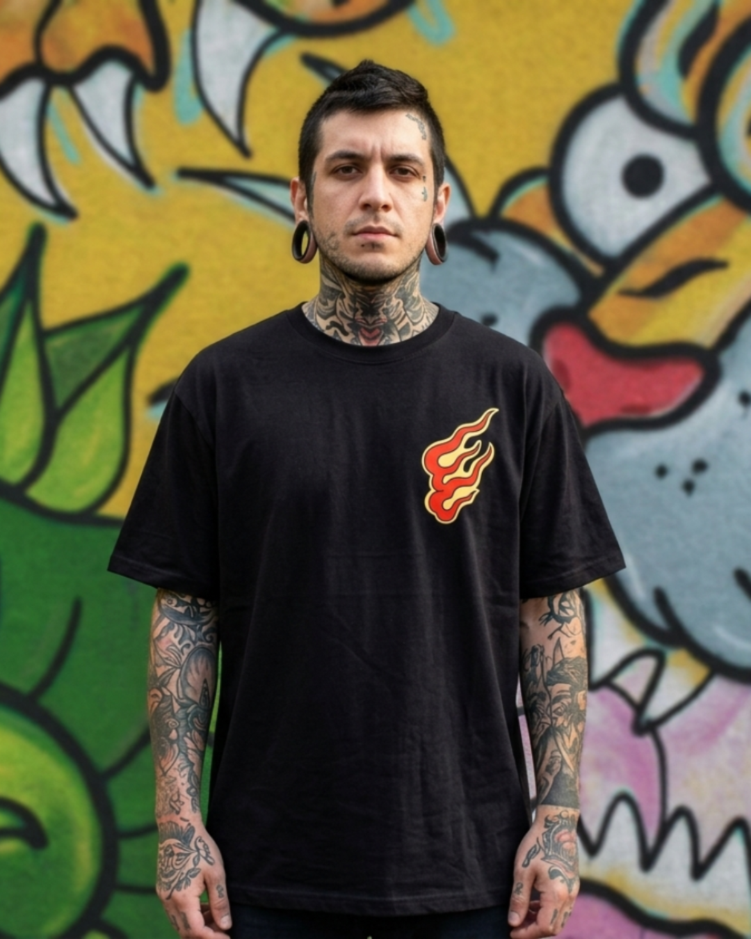 Modelo masculino con tatuajes usando camiseta negra Oni no Hono. Detalle del diseño de llama técnica tradicional en el pecho.