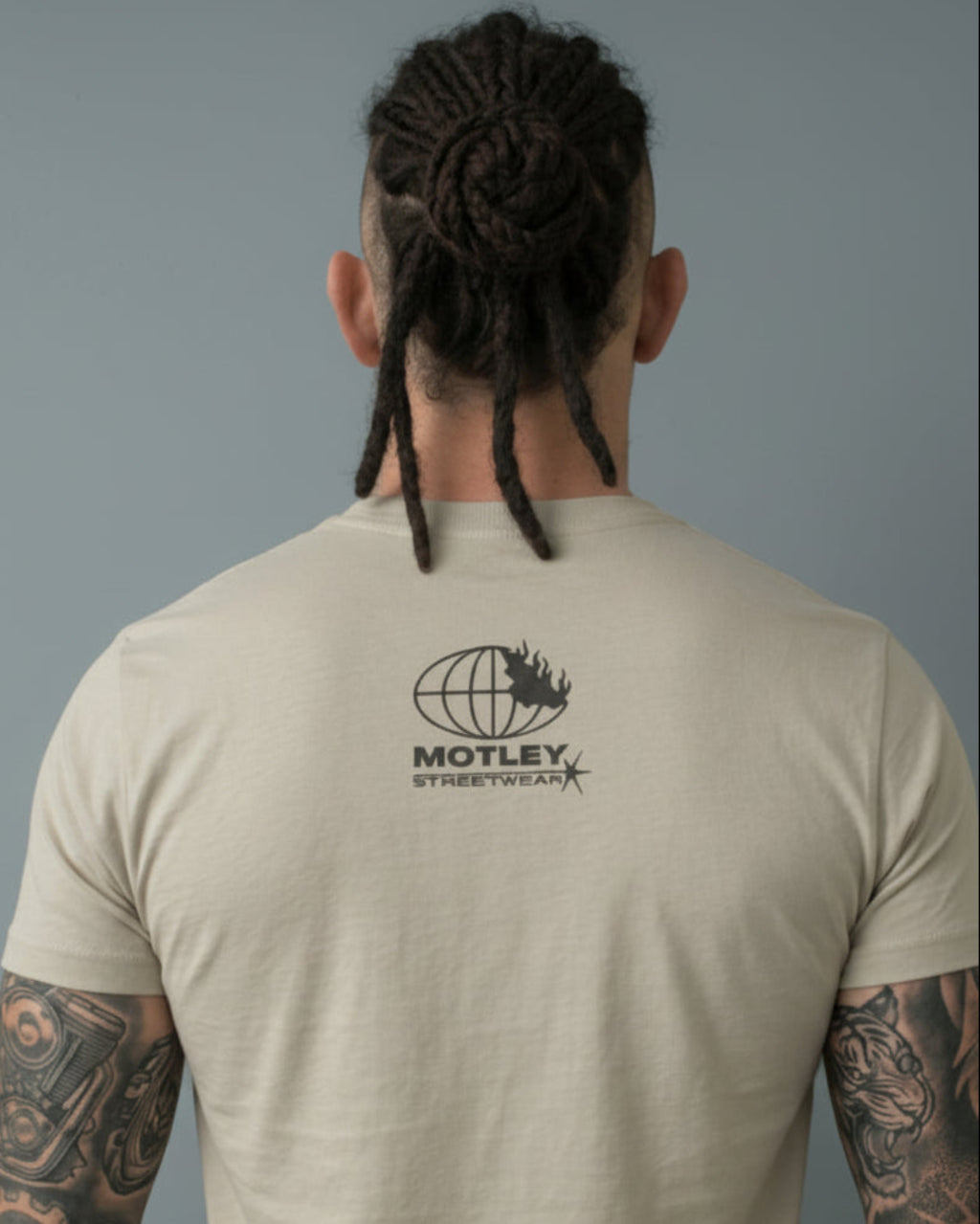 Vista posterior de camiseta Motley Streetwear. Detalle del logo minimalista en el cuello y caída de tela premium.